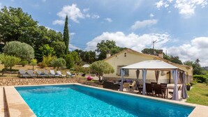 A swimming pool with lounge chairs and a covered seating area. - Vacation home Antem by Interhome (Lloret de Mar)