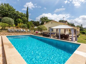 A swimming pool with lounge chairs and a covered seating area. - Vacation home Antem by Interhome (Lloret de Mar)