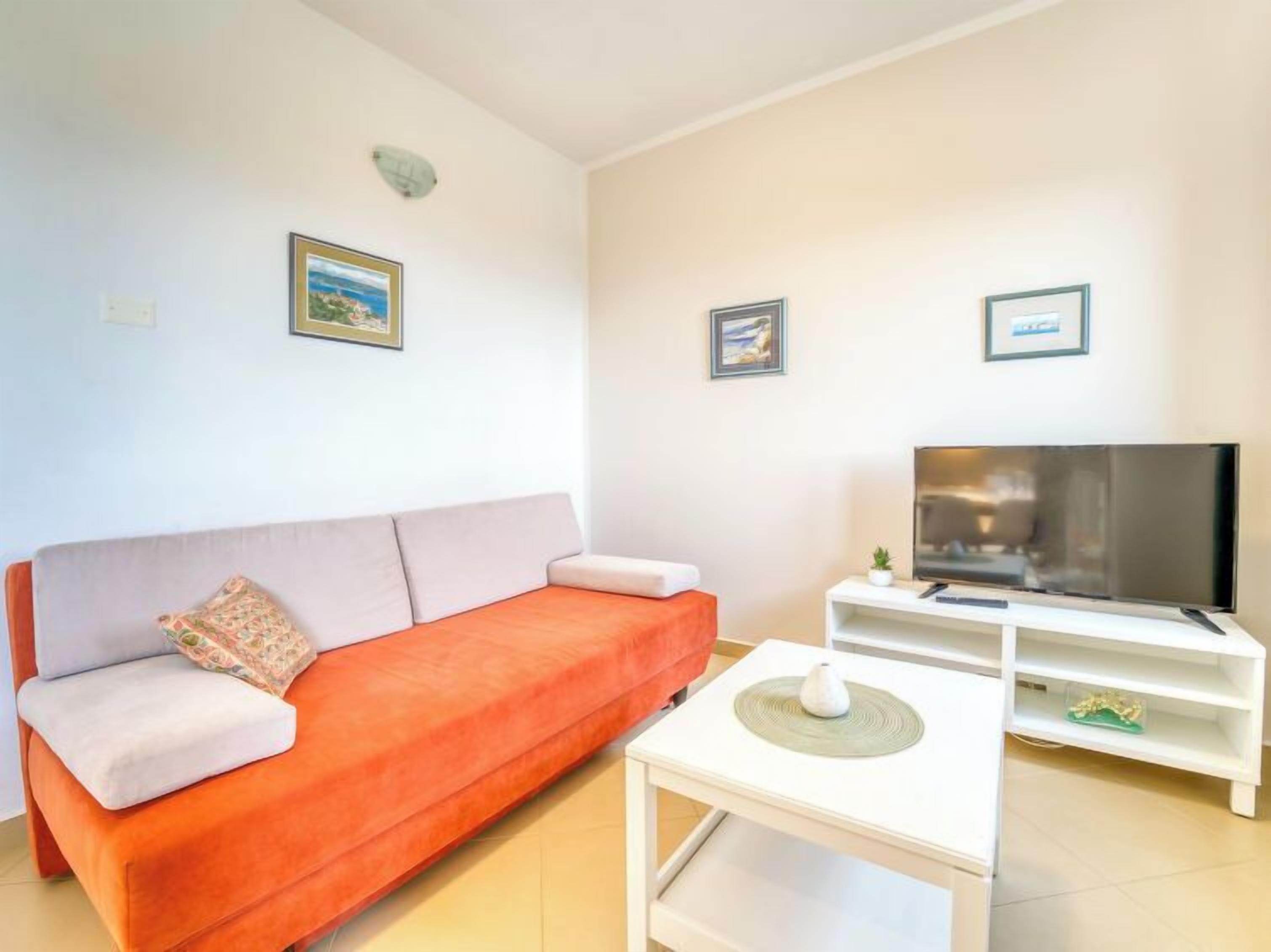 A living room with a sofa, a TV, and a small table.
