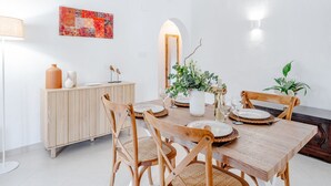 Un comedor con una mesa de madera, sillas y un armario.