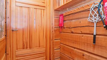 A wooden interior with a door, a wall-mounted rack, and a red sign.
