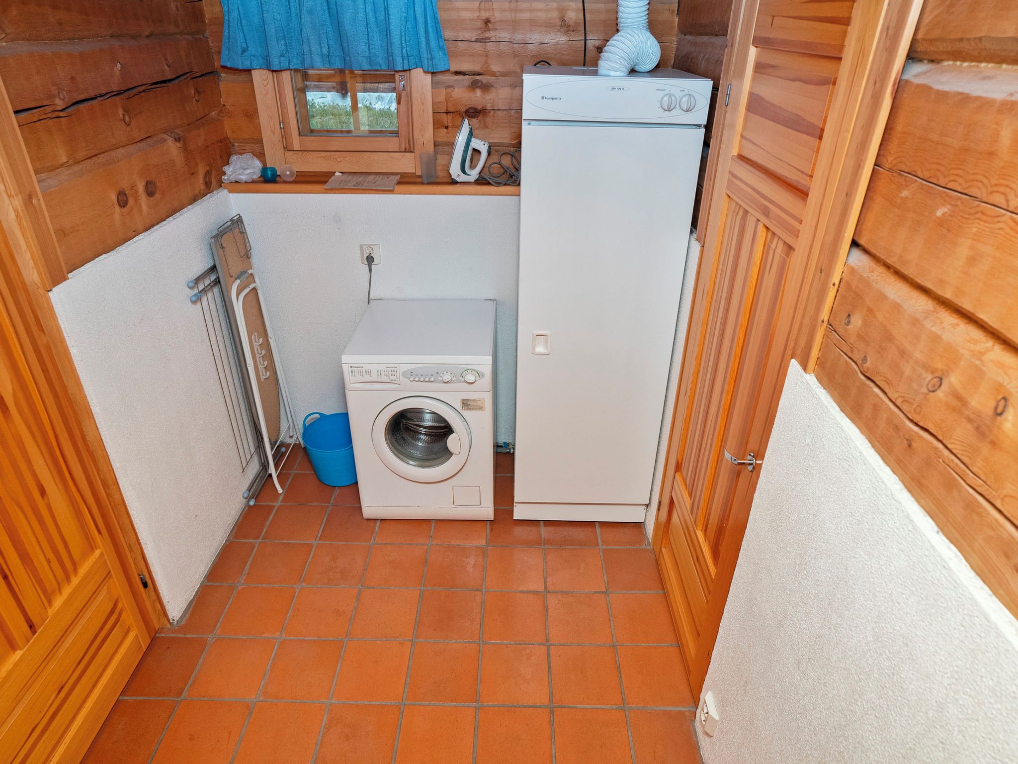 A compact laundry room with a washing machine, a dryer, and a small window.