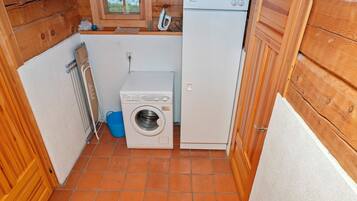 A compact laundry room with a washing machine, a dryer, and a small window.
