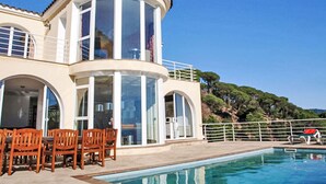 A two-story building with a swimming pool, outdoor seating, and a view of the surrounding landscape. - Vacation home Gaudí by Interhome (Lloret de Mar)