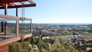 A modern building with a glass balcony overlooking a town. - Mas Ambros by Interhome (Calonge)