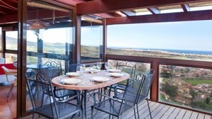 A dining area with a table set for four, overlooking a scenic landscape. - Mas Ambros by Interhome (Calonge)
