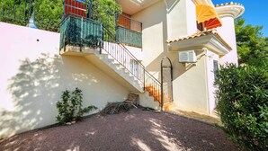 A two-story house with a white exterior, a staircase, and a small garden area. - Bonalba Golf, Urb. Los Naranjos by Interhome (San Juan / Muchamiel)