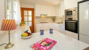A modern kitchen with white cabinets, a built-in oven, and a refrigerator. - Bonalba Golf, Urb. Los Naranjos by Interhome (San Juan / Muchamiel)