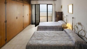 A bedroom with two beds, a wardrobe, and a view of the sea. - Urb.Maricel by Interhome (Alcanar)