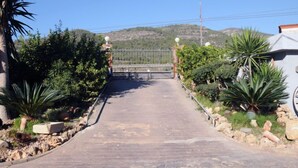A paved pathway leading to a gated entrance with a metal fence and decorative posts. - Urb.Maricel by Interhome (Alcanar)