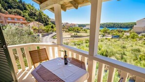 A balcony with a table, chairs, and a bottle of wine. - Pavica 5 by Interhome (Rab/Rab)