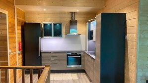 Une cuisine moderne avec des murs en bois, un four encastré et une hotte de cuisine en acier inoxydable.