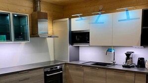 Une cuisine moderne avec des meubles en bois, un four encastré et un évier en acier inoxydable.
