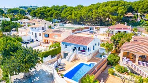 Zona residencial con piscina, casas adosadas y abundante vegetación.