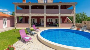 Un bâtiment à deux étages doté d’une piscine, d’un espace extérieur aménagé et d’un jardin.