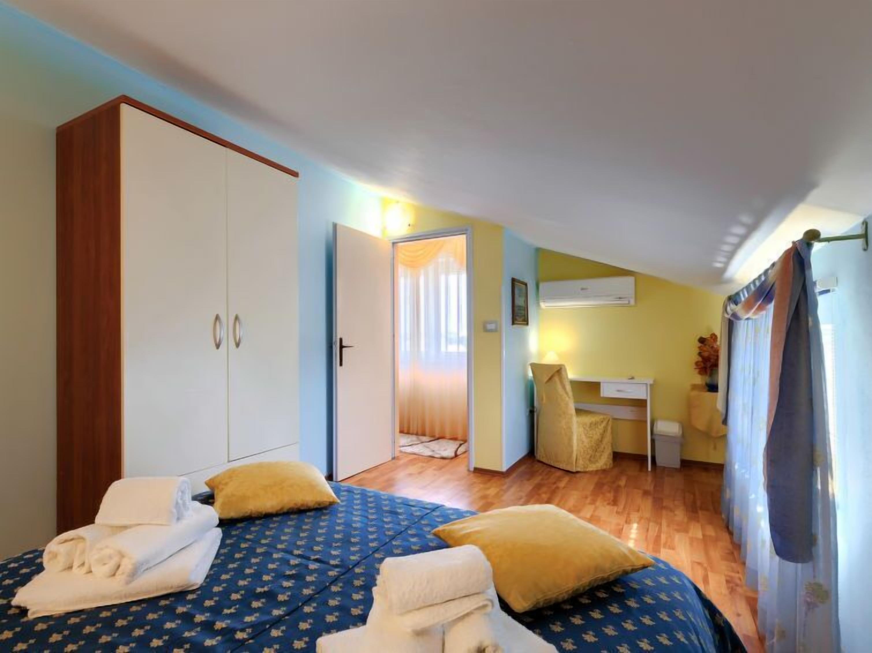 Une chambre d’hôtel avec un lit, un bureau et une armoire.