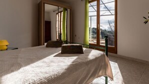 Una camera da letto con un letto grande, uno specchio e una finestra con vista sull'esterno.