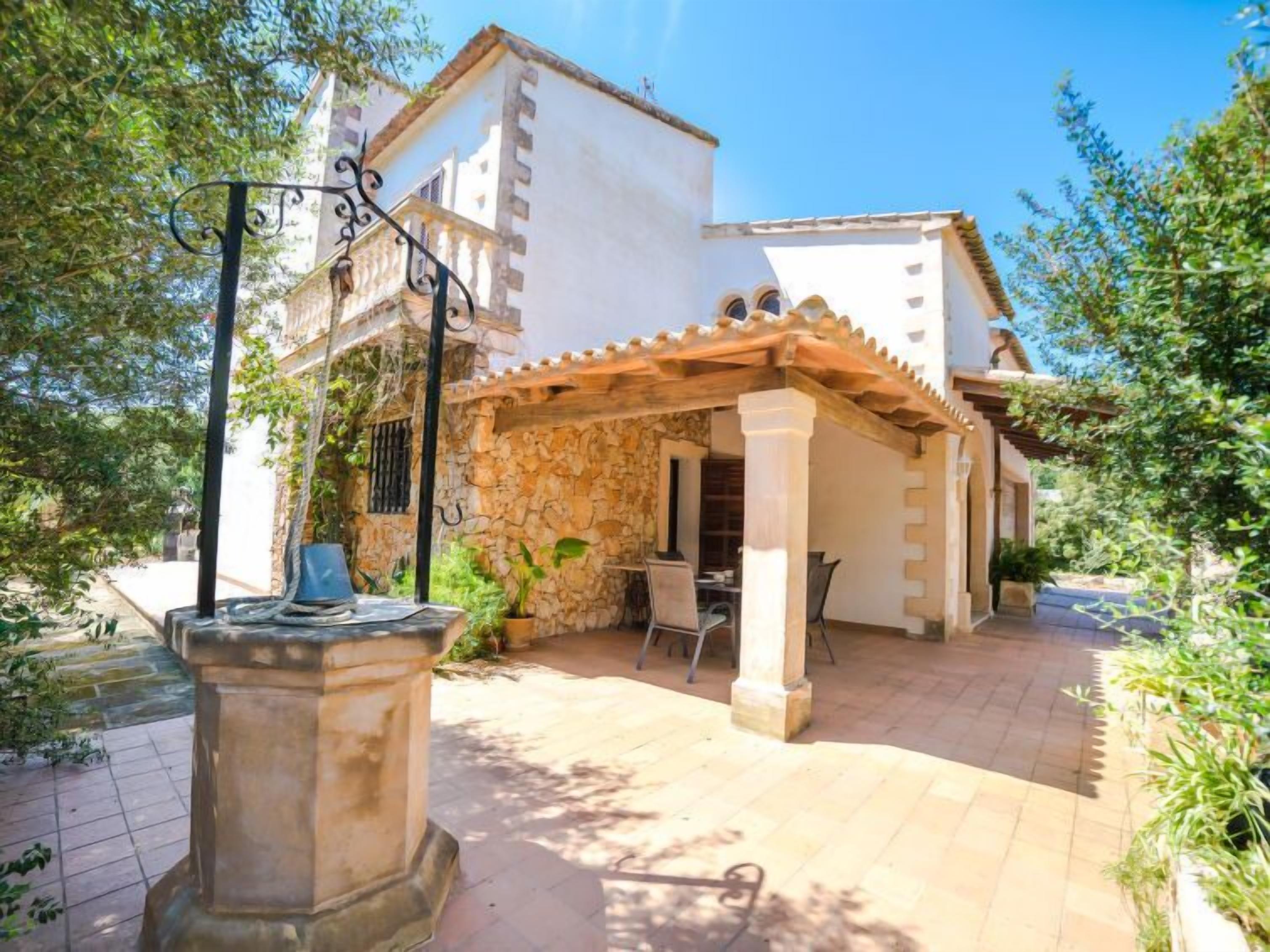 Pátio com fonte de pedra, área de estar ao ar livre e pérgola.