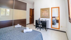 A bedroom with a bed, a desk, a chair, a wardrobe, and a painting on the wall. - Vacation home Sanso by Interhome (Porto Cristo)