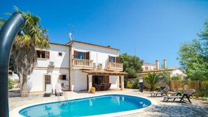 A two-story house with a swimming pool, outdoor furniture, and a stone patio. - Vacation home Sanso by Interhome (Porto Cristo)