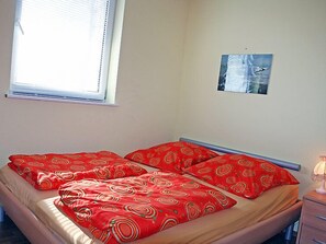 Ein Schlafzimmer mit einem Bett, einem Fenster und einem Wandbild.