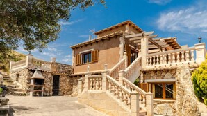 A two-story house with a stone facade, wooden shutters, and a stone staircase leading to the upper floor. - Cala Torta Na Lluny by Interhome (Cala Torta)
