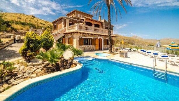 A two-story building with a pool, surrounded by greenery and a clear blue sky. - Cala Torta Na Lluny by Interhome (Cala Torta)
