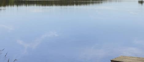 Ein ruhiger See mit einem hölzernen Steg, der ins Wasser ragt.