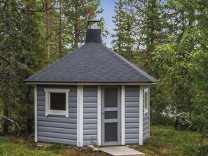 A small cabin with a gabled roof, a front door, and a window.
