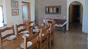 Ein Essbereich mit Backsteinwand, Holzmöbeln und gerahmten Bildern.