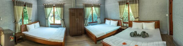 A room with three wooden beds, a wooden wardrobe, and a fan.