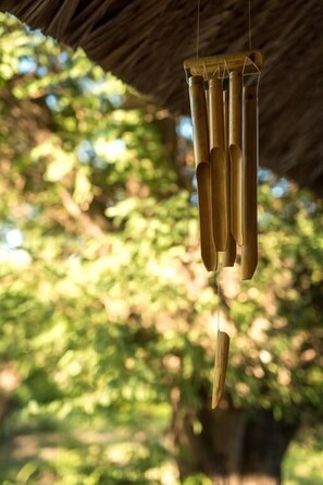 A bamboo wind chime hanging outdoors. - Jungle Beach (Dong Ninh Hoa)