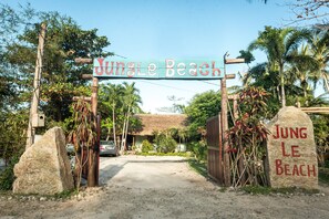 A sign reading "Jungle Beach" with a thatched-roof building in the background. - Jungle Beach (Dong Ninh Hoa)