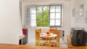 Un coin repas avec une table en bois, des chaises et un téléviseur.