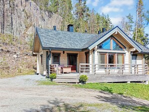 Een lodge met een overdekte veranda, een eethoek en een groot raam.