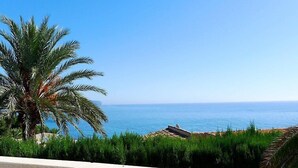 A balcony with a view of the sea, a palm tree, and a beach in the background. - Vacation home Avalon by Interhome (Calpe/Calp)