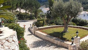 Ein gepflegter Garten mit einem Kiesweg, der zu einem Blick auf die Berge einlädt.