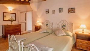 A bedroom with a double bed, wooden headboard, a dresser, and a nightstand with a lamp. - Casa Graziani by Interhome (Città della Pieve)