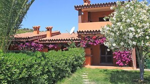 A two-story building with a tiled roof, satellite dish, and flower boxes. - Marrone by Interhome (Costa Rei)