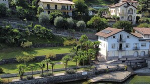 A coastal property with a white building, a stone wall, and a small dock.