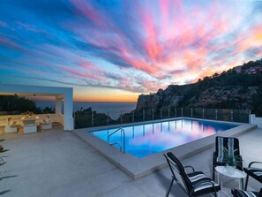 A rooftop infinity pool with a view of the ocean and a sunset sky. - Vista al Mar by Interhome (Moraira)