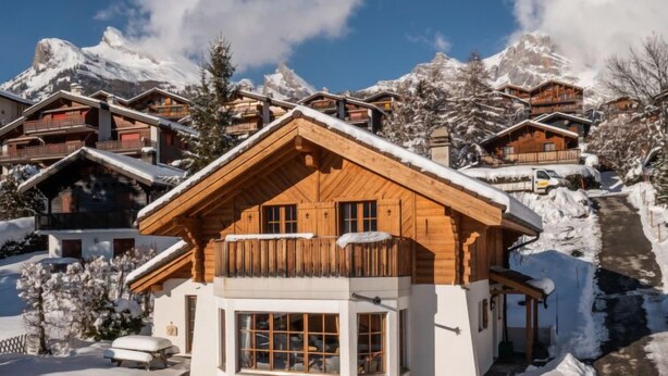 Un edificio de estilo chalete con fachada de madera, ventanas grandes y un balcón.