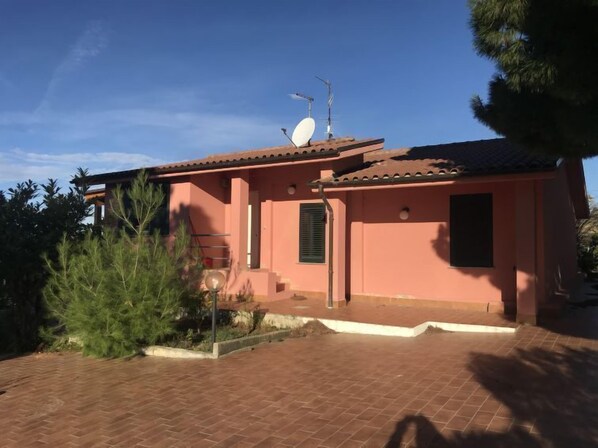 A small, single-story building with a tiled roof and a satellite dish.