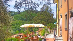 An outdoor patio with stone walls, potted plants, and outdoor seating.