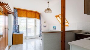 Una cuina moderna amb una illa central, detalls de fusta i vistes cap a l'exterior.