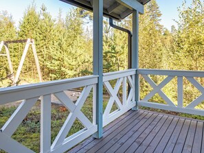 A wooden deck with a white railing, overlooking a forested area. - Klz 3. malakiitti by Interhome (Sotkamo)
