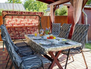 An outdoor dining area with a table set for four, surrounded by patterned chairs. - Hibiscus by Interhome (Balatonkeresztur)