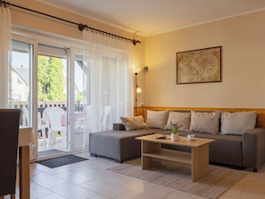 Un salon avec un canapé, une table basse et une carte accrochée au mur.