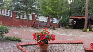 A garden area with a brick pathway, a wooden bench, and a white fence. - Mielno 2 by Interhome (Grunwald)
