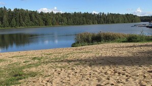 A sandy beach with a calm lake, surrounded by dense forest. - Mielno 2 by Interhome (Grunwald)